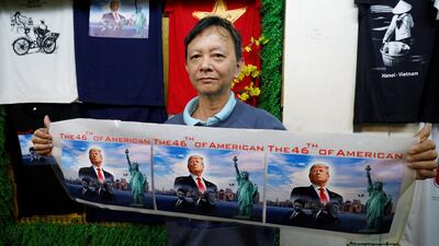 Vietnamese souvenir seller Truong Thanh Duc, supporter of US President Donald Trump, shows images of the president at his shop in Hanoi, Vietnam. Reuters