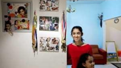 Eleanor Furtado, in red, with her sister Kelly Ann at their family home. Eleanor scored 95% overall at Our Own English High School in Dubai and hopes to attend college in India, where she is from.