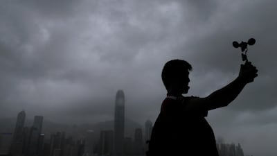 A man raises an anemometer against the strong wind caused by tropical storm Pakhar on the waterfront of Victoria Habour in Hong Kong. Vincent Yu / AP Photo