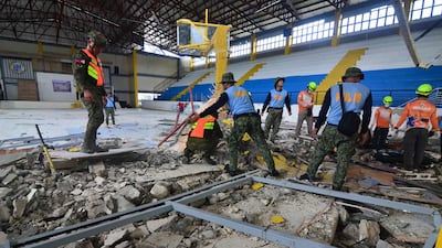Emergency responders inspect the damage at an indoor arena in San Remigio town, Cebu province. AFP