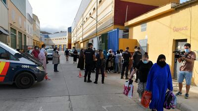 Policemen check passports of Moroccan woman, stranded in Spain due to coronavirus crisis, in the Spanish enclave of Ceuta. AFP
