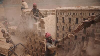 Brick factory workers stack bricks on a cart to take them to the warehouse in Dhaka, Bangladesh. Mohammad Ponir Hossain / Reuters
