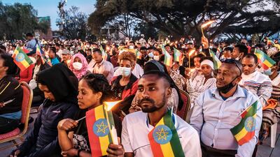 People hold candles and Ethiopian flags at a memorial service for the victims of the Tigray conflict in Addis Ababa.