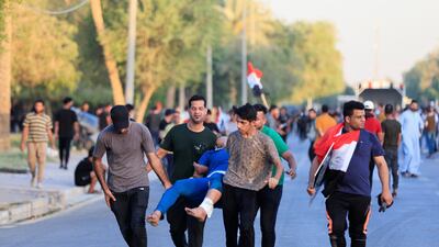 Supporters of Mr Al Sadr carry a person during a protest against corruption in the Green Zone in Baghdad. Reuters