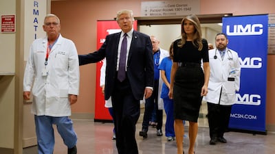 President Donald Trump and first lady Melania Trump walk through University Medical Center after meeting with victims of the mass shooting. Evan Vucci / AP Photo