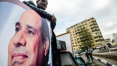 A supporter of Egyptian President Abdel Fattah El Sisi stands in the back of a pickup truck bearing his portrait and loudspeakers, in the capital Cairo's Tahrir square on January 25, 2018. AFP / MOHAMED EL SHAHED