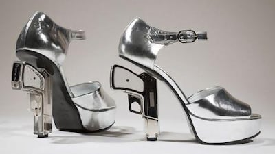 Silver platform shoes designed by Chanel with guns as heels. AP Photo / Fashion Institute of Technology