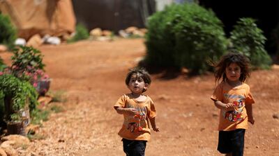Children run near tents at a camp for internally displaced people in northern Idlib, Syria. Reuters