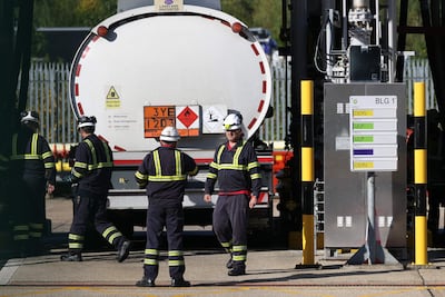 Technicians fill a tanker with petrol at an oil depot north of London. A shortage of HGV drivers pushed petrol firms into rationing deliveries. AFP