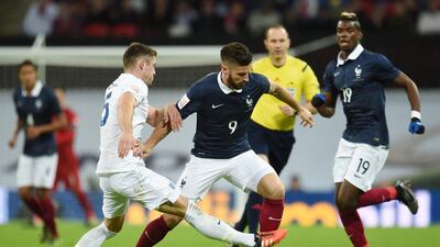 England’s Gary Cahill vies for the ball with Olivier Giroud of France. Andy Rain / EPA