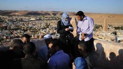 Tourists admire the view from atop a mud minaret in the old town of Beni Isguen.