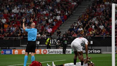 Referee Anthony Taylor calls for medics after a clash of heads between Sevilla's Nemanja Gudelj and Roma's Roger Ibanez. AFP