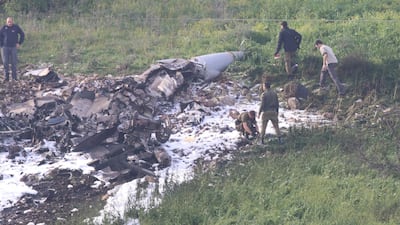 Israeli security forces walk next to the remains of an F-16 warplane near the village of Harduf, Israel on February 10, 2018. Herzie Shapira / Reuters