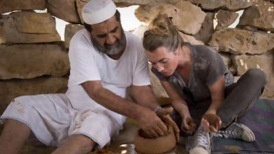 Ruth Impey, a professional potter based in Abu Dhabi learns to make a traditional pot from Ahmed Rashed Mohammed Al Haymar, 60, in his father's old home in Wadi Haqil. Razan Alzayani / The National