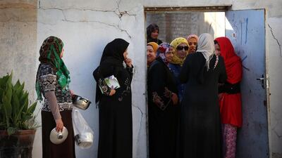 Displaced Iraqi families, who fled the ongoing conflict between pro-government forces and Islamic State (IS) group jihadists, wait to receive food prepared by Iraqi Kurdish women at a mosque in Arbil, the capital of the autonomous Kurdish region of northern Iraq. Safin Hamed / AFP