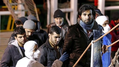 Migrants arrive on a boat at the Sicilian harbour of Pozzallo on Monday. Alessandro Bianchi / Reuters