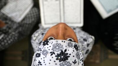 A Palestinian girl reads the Koran during the holy month of Ramadan at a mosque in Rafah in the southern Gaza Strip. Ibraheem Abu Mustafa / Reuters