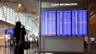A traveller looks at a flight information board at Ronald Reagan Airport in Arlington, Virginia. AFP