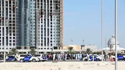 Police and labourers pictured on Reem Island on Sunday. Khushnum Bhandari / The National