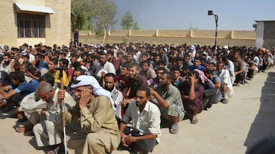 Displaced Iraqi people, who fled ISIL violence, wait for security checks on the outskirt of Al Qayyarah in Mosul district. Reuters