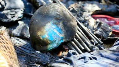 A press helmet is seen next to a destroyed vehicle hit by an Israeli strike that was carrying Ali Shoeib, Fatima Ftouni and Mohammed Ftouni. EPA