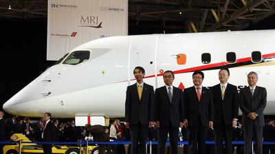 Mitsubishi Aircraft president Teruaki Kawai, left, All Nippon Airways CEO and president Shinichiro Ito, second left, Japanese deputy land, infrastructure, transport and tourism minister Akihiro Nishimura, centre, Japanese deputy education, culture, sports and science minister Hideki Niwa, second right, and Mitsubishi Heavy Industrires chairman Hideaki Omiya, right, pose in a photo session during a ceremony of the Mitsubishi Regional Jet. Toshifumi Kitamura / AFP