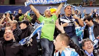 Malaga supporters celebrate during the Champions League group stage match with Anderlecht. The on-field success has been dampened by the off-field issues with Uefa over the Financial Fair Play rules and the Spanish government over tax payments.
