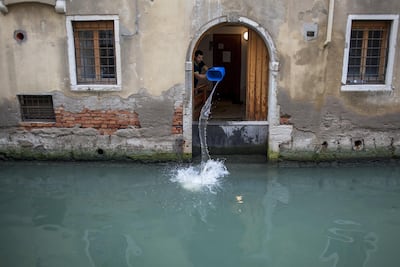 A worker clears excess water from a house following recent flooding. Bloomberg