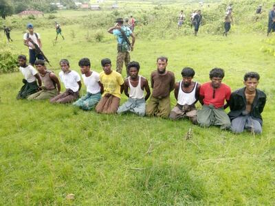 Ten Rohingya Muslim men with their hands bound kneel as members of the Myanmar security forces stand guard in Inn Din village on September 2, 2017. Reuters
