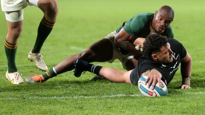 New Zealand's centre David Havili (FRONT) is tackled by South Africa's wing Makazole Mapimpi as he scores a try during the Rugby Championship international rugby match between South Africa and New Zealand at Emirates Airline Park in Johannesburg on August 13, 2022. (Photo by PHILL MAGAKOE / AFP)