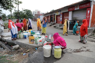 Indian migrant labourers collect water from a roadside tap during the lockdown to combat the spread of Covid-19, Jammu, India, May 14. Jaipal Singh / EPA
