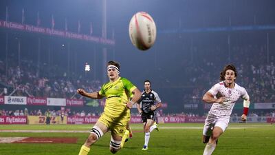 England, in white, faced Australia, in yellow on Day 2 at the Dubai Rugby Sevens. Victor Besa for The National
