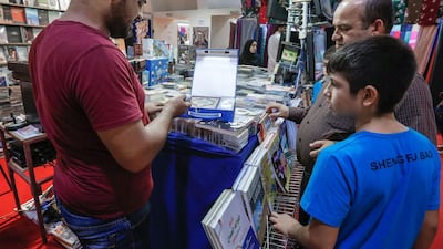 Ibrahim Miri buys a Quran with an electric pen for quick reference from one of the vendors at Fujairah's Eid fair on September 8, 2016. Victor Besa for The National