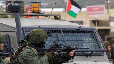 An Israeli soldier aims fire during clashes with Palestinian youths in the village of Qabatiya, near the West Bank town of Jenin on February 6, 2016. Jaafar Ashtiyeh / AFP Photo