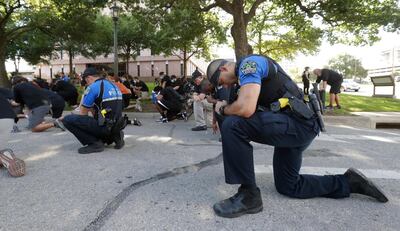 Austin police officers takes a knee with members of the University of Texas football team at the Texas State Capitol. AP Photo