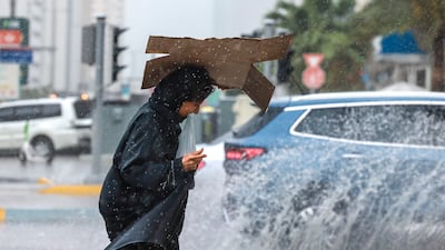 A woman rushes for cover during a spell of rain in Abu Dhabi. Victor Besa / The National
