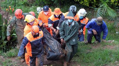 Rescuers carry the body of a victim caught in a landslide caused by Typhoon Kompasu in Baguio city, northern Philippines. AP Photo