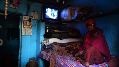 A cured patient of leprosy looks on as she watches television.