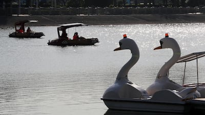 People enjoy the solar power boat ride at the Al Barsha pond park in Dubai. Pawan Singh / The National