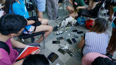 People charge their phones for free at a mall as most parts of Cebu city, central Philippines, remain without electricity. AP