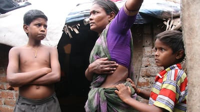 Nagamma, a victim of organ traffickers, with two of her three sons in front of her shack in the Korukkupet area of Chennai, India. Shaikh Azizur Rahman for The National