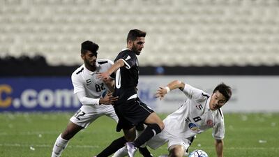 Sultan Abdulaziz, left, and Park Jong-woo of Al Jazira compete against Hasan Al Haydos of Al Sadd. Jeffrey E Biteng / The National