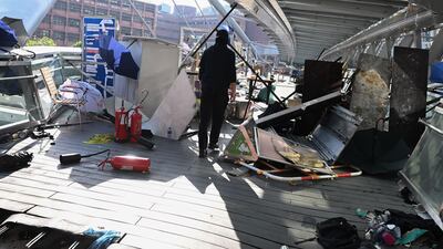 A protester walks past debris piled at a barricade on the campus. AFP