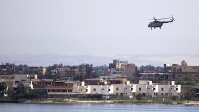 A military helicopter flies above a container ship in the Suez Canal. Amr Abdallah Dalsh / Reuters