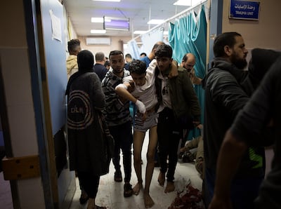 A wounded person is helped inside Nasser Hospital, in Khan Younis. EPA