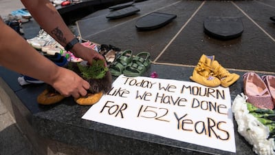 Shoes line a fountain in memory of the 215 children whose remains were found at the grounds of the former Kamloops Indian Residential School, British Columbia, Canada. AP