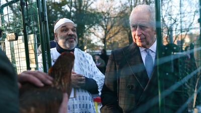 The monarch inspects a chicken during a tour of a community kitchen in Harrow, Greater London. Getty