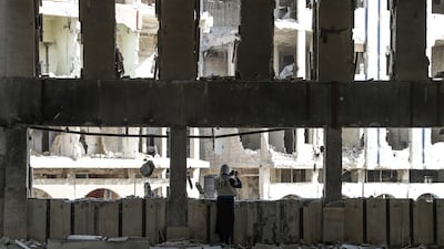 A woman from the World Food Program (WFP) takes pictures after meeting with civilian activists and local council of Douma to discuss the civil situation in Douma, in Eastern Ghouta, on March 5, 2018.Mohammed Badra / EPA