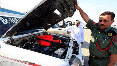 Members of the Dubai Police department with one of the cars, which was modified to use jet fuel, that they caught racing at 300kph on the Dubai bypass.