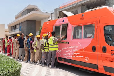 Workers in Dubai receive water and frozen treats from an Al Freej Fridge van. Photo: Mohammed bin Rashid Maktoum Global Initiatives / Ferjan Dubai